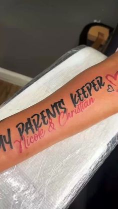 a person with a tattoo on their arm that says, my parents keeper nicole and christian