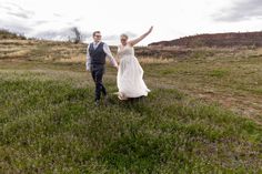 a bride and groom are walking through the grass