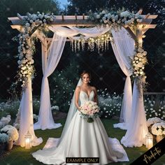 a woman in a wedding dress standing under an arch with flowers and candles on it