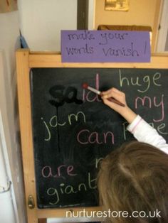 a child writing on a blackboard with magnets