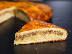 a piece of bread that has been cut in half on a black surface with one slice missing