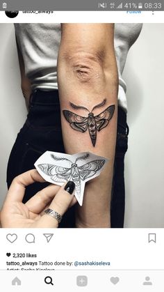 a woman's arm with a tattoo on it and a moth in the middle