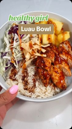 a bowl filled with rice and chicken next to pineapples, cabbage and coleslaw