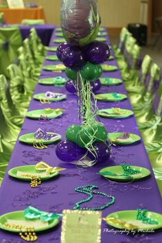 purple and green table cloth with plates and balloons