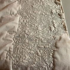 a close up of a piece of cloth on a table with an intricate design in the middle