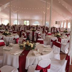 a banquet hall with tables and chairs covered in red sashes