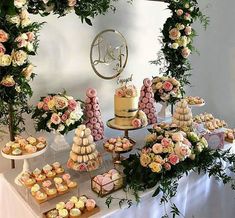 a table topped with lots of cupcakes next to a cake and dessert display