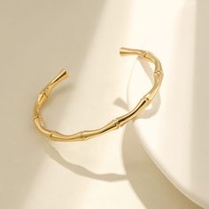 The Bamboo Bangle Embrace nature's elegance with our Gold Bamboo Bangle, a timeless piece that complements your style effortlessly. Crafted with care, this bangle captures the organic beauty of bamboo in a sleek and versatile design. Made from high-quality materials, it's all about simplicity and sophistication. Whether you're dressing up or keeping it casual, this bangle adds a touch of natural charm to your everyday look. Length: Around 7" Open, slightly adjustable Material: Stainless Steel, H Cheap Summer Bangle Jewelry, Cheap Minimalist Bangle For Gifts, Affordable Gold Metal Bangle, Luxury Minimalist Gold Plated Bangle, Luxury Gold Minimalist Bangle, Trendy Cheap Gold Bangle, Luxury Handmade Minimalist Bangle, Chic Cheap Gold Bangle, Cheap Modern Bangle For Women