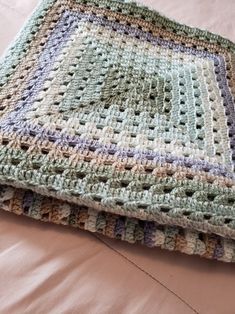 a crocheted blanket laying on top of a bed