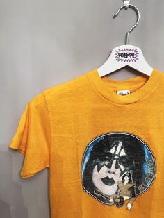 Ace Frehley KISS Vintage 70s Tee Extremely rare, original KISS tshirt. Printed on Ched blank. Date: 1970s~ Size: S No significant flaws. Some cracking to print. Pit-to-pit: 37.5cm Length: 64.5cm Unisex Retro Top With Band Logo, Retro Band Logo Tops, Unisex Retro T-shirt For Fan Merchandise, Retro Fan Merchandise T-shirt, Retro Unisex T-shirt For Fan Merchandise, 70s T Shirts Vintage Tees, Vintage T-shirt For Concerts, Unisex Vintage T-shirt For Concert, Vintage Unisex T-shirt For Concert