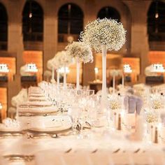 the table is set with white flowers and place settings for guests to sit down at