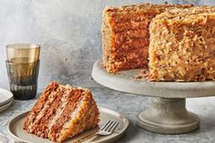 a piece of carrot cake on a plate next to a slice of cake and a fork