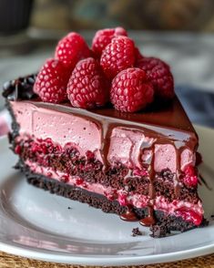 a slice of chocolate raspberry cheesecake on a plate with fresh raspberries