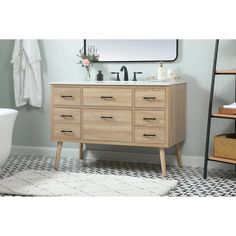 a white toilet sitting next to a wooden sink vanity in a bathroom under a mirror