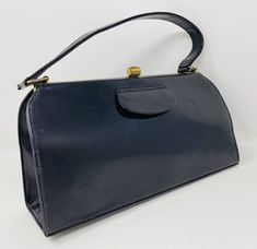 This is a really lovely vintage navy blue leather Kelly style handbag, made in England.  It is in good condition, apart from a vertical line indentation on the front right, as shown in the photos - so if you want your handbag to be near perfect, this isn't the bag for you - but if you're ok with it having this small flaw, then it *is* the bag for you. I've adjusted the price to take account of the indentation.  The dimensions are 11 x 5.5 x 3 inches.  The interior is a nice silky blue.  (not fou Maroon Leather, Patent Leather Handbags, Top Handle Bags, How To Make Handbags, Tan Suede, Black Patent Leather, Leather Handbag, Blue Leather, Purses And Handbags