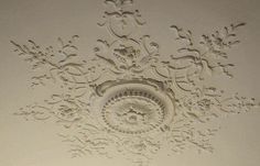 the ceiling is decorated with white paint and ornate designs, including an intricate design on the ceiling