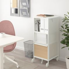 a white bookcase sitting next to a pink chair in a living room with a potted plant