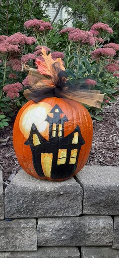 a decorated pumpkin sitting on top of a stone wall