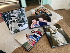 several family photos are placed on the counter top next to an open book with pictures of people and a dog