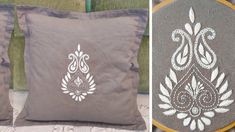 two pillows with embroidered designs on them sitting next to each other