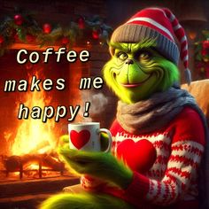 the grinch is holding a coffee mug in front of a fireplace