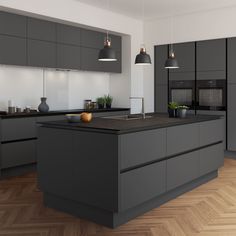 a modern kitchen with grey cabinets and black counter tops, an island in the middle