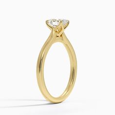 a yellow gold engagement ring with a pear shaped diamond