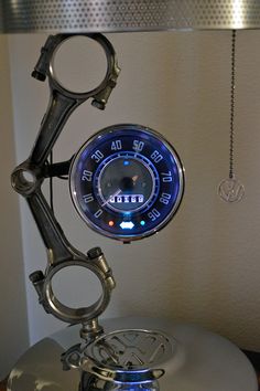 a close up of a clock on top of a metal object with scissors attached to it