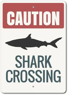 there is a sign that says caution shark crossing