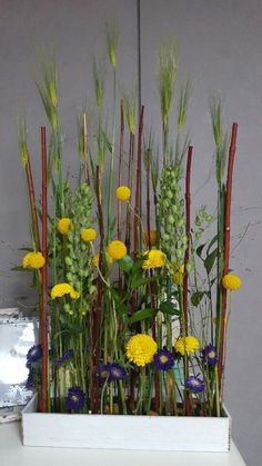 a white planter filled with yellow and purple flowers