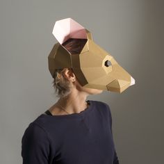 a woman wearing a paper animal mask on her head