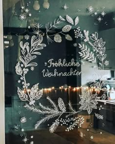 the window is decorated with frosting and christmas lights in front of a kitchen counter