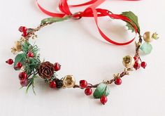 a headband with holly, berries and pine cones