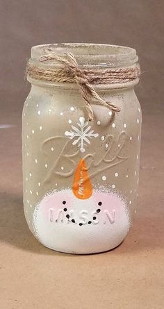 a mason jar decorated with snowflakes and a carrot on the lid, sitting on a table