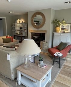 a living room filled with furniture and a lamp on top of a wooden coffee table