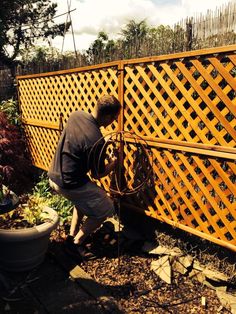 a man is working on an outdoor fence