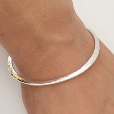 This sterling silver bangle is hammered into a rounded triangular shape. It is a very solid bracelet.  This elegant bracelet can be worn alone or stacked with other bangles.  I offer different sizes of this bangle.  To determine the right size for you, make a fist and rest it on a flat surface.  Measure the distance from the middle of your first knuckle to the middle of your fourth knuckle.  The unit of bangle size is inches, and an inch is further divided into 16 parts. When we say a bangle siz Cardboard Jewelry, Hammered Bracelet, Hammered Bangles, Bangle Silver, Hammered Hoop Earrings, Cardboard Jewelry Boxes, Circle Bracelet, Luxe Jewelry, Sterling Silver Bangle