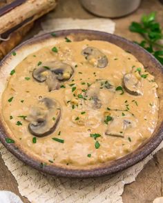 a bowl filled with mushroom soup and garnished with parsley on the side