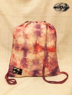 a tie - dyed bag sitting on top of a white sheet