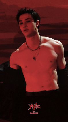 a shirtless man with no shirt standing in front of a red background