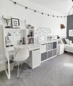 a white desk and chair in a room with lights on the wall above it, along with other furniture