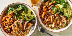 two bowls filled with meat and vegetables next to a glass of orange juice on a table