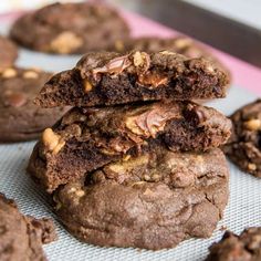 chocolate cookies with walnuts and sea salt are stacked on top of each other in front of the rest of the cookies