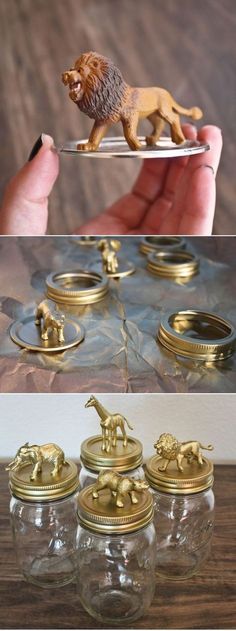 a person holding a glass jar filled with gold figurines on top of a wooden table