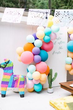 a colorful party with balloons and a llama