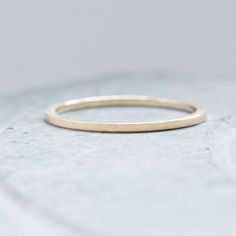 a thin gold ring sitting on top of a white surface