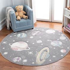 a child's room with a teddy bear sitting on a chair in front of the rug