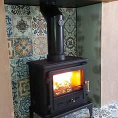 a wood stove in front of a colorful wall with tiles on the walls and floor