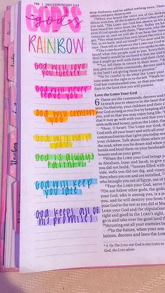 an open bible with rainbow writing on it