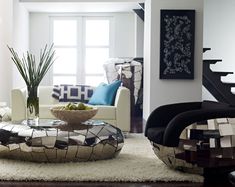 a living room filled with furniture and a large mirror bowl on top of a coffee table